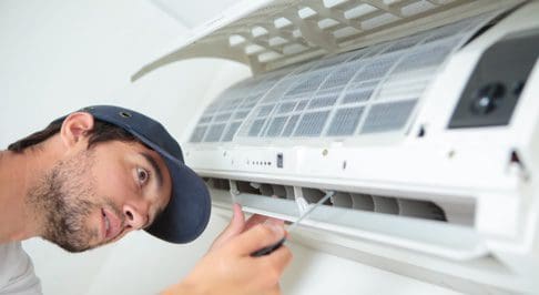 person fixing in-wall ac unit