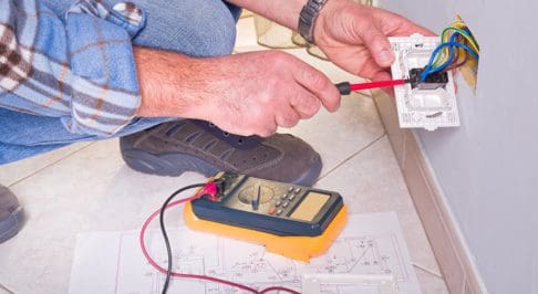 person working on a wall outlet or patch panel